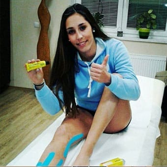 Female athlete massaging her knee with Muay cream